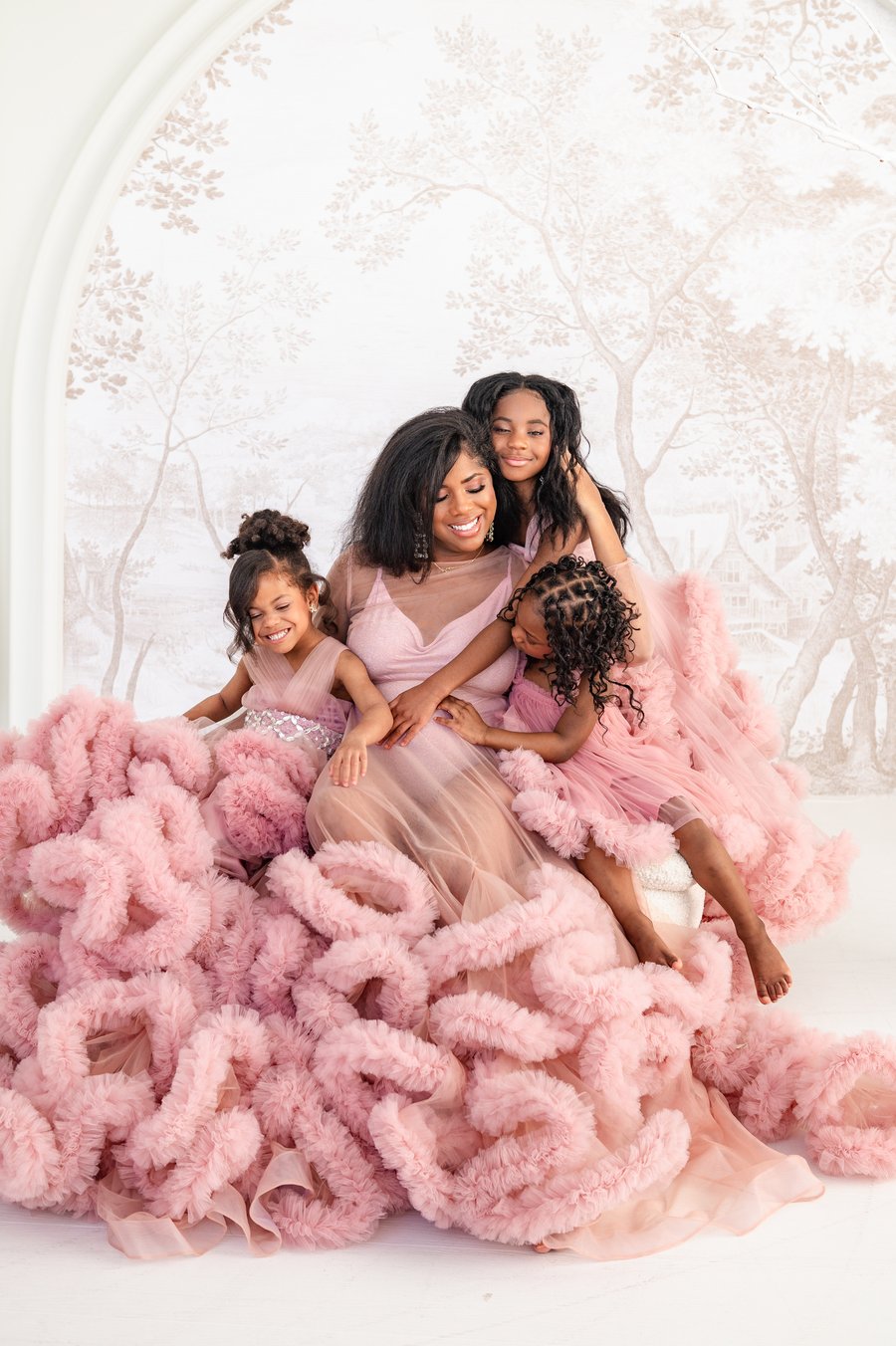 Mother and daughters in pink gowns